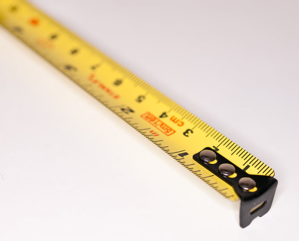 a yellow measuring tape with a black handle