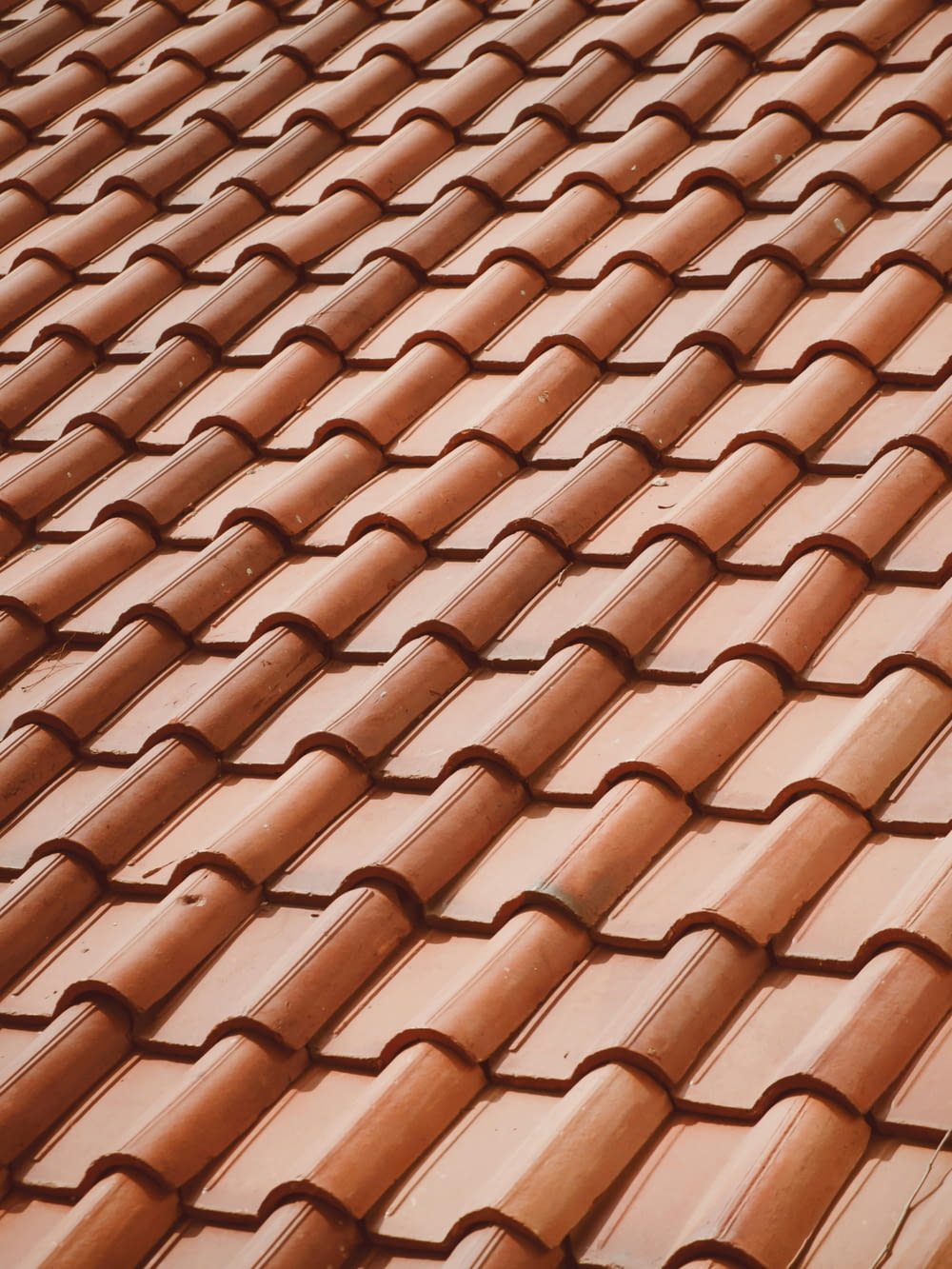 a close up of a roof with a red tile pattern