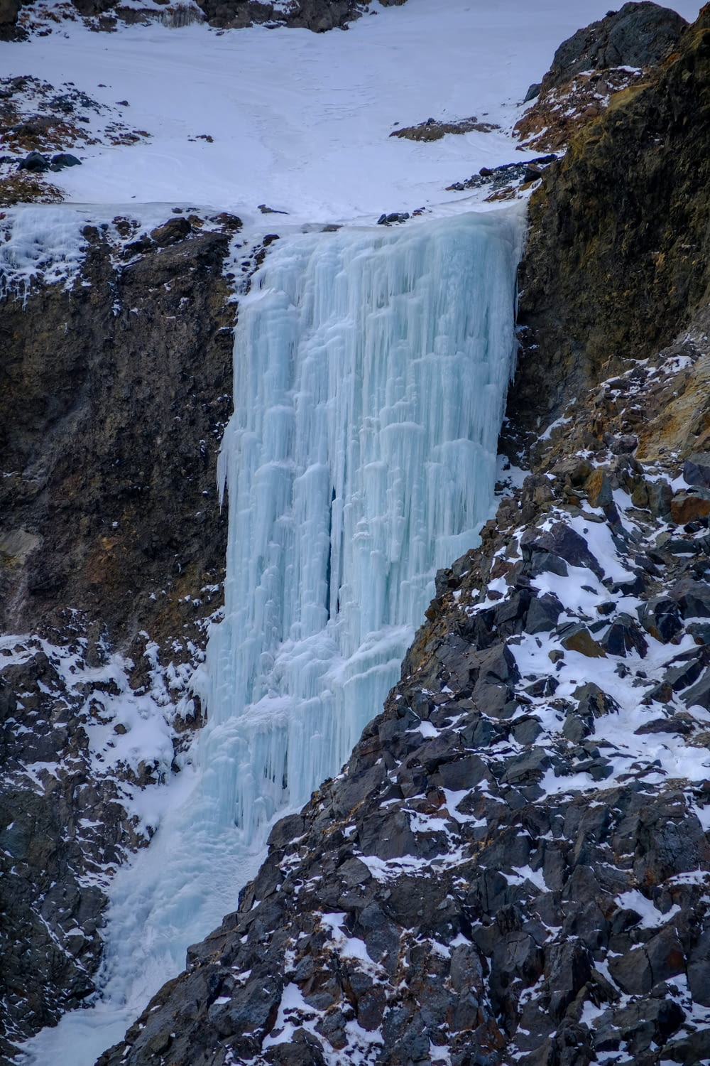 a frozen waterfall in the middle of a mountain