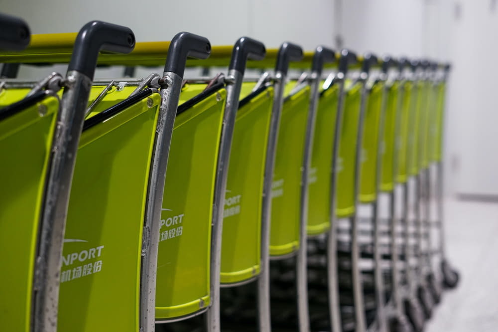 a row of lime green shopping carts with black handles