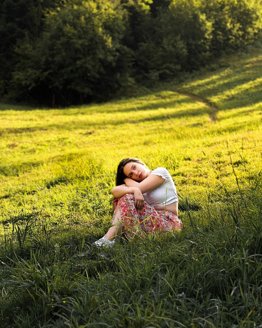 a woman sitting in a field of green grass