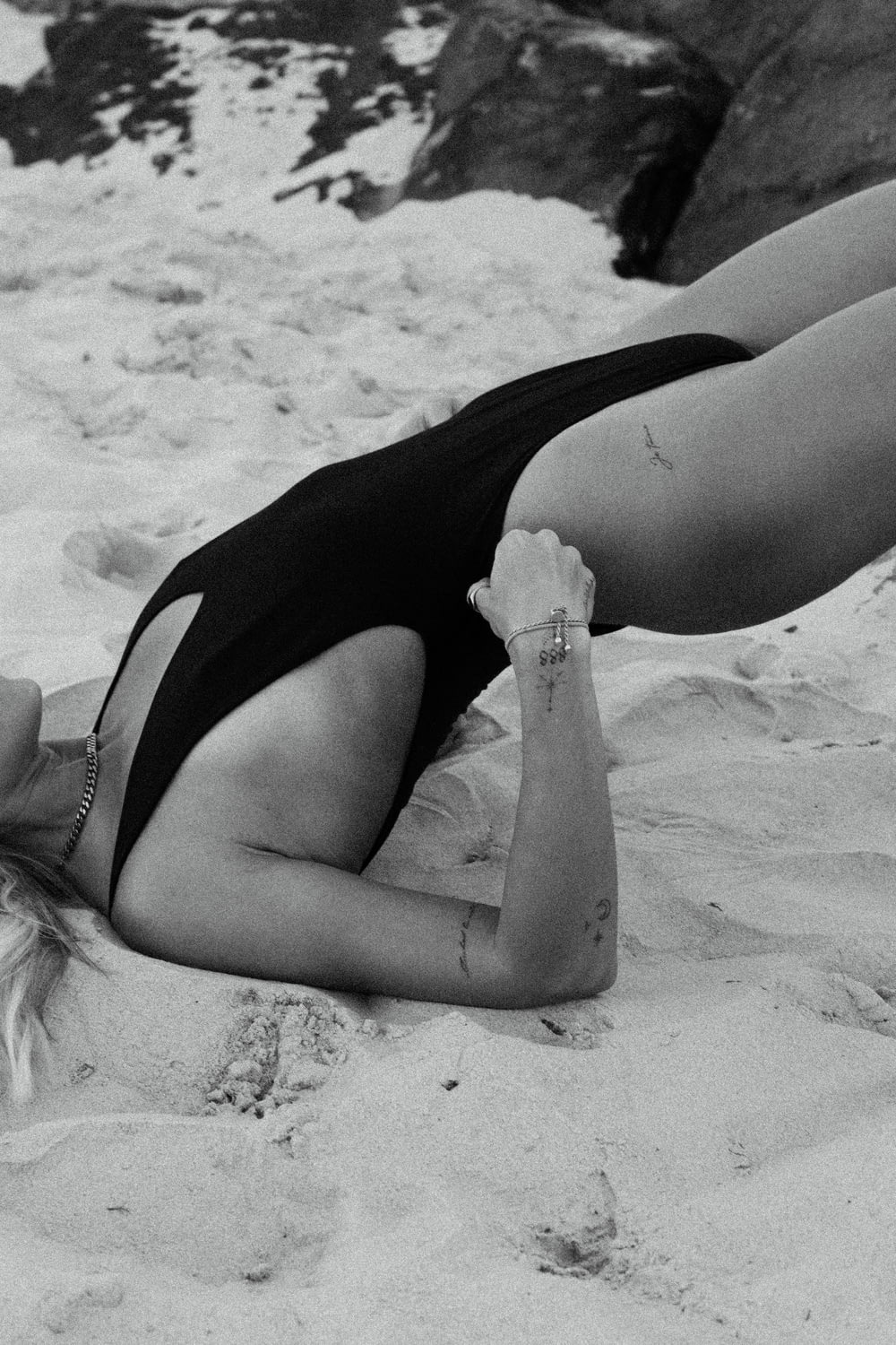 a woman in a bathing suit laying in the sand