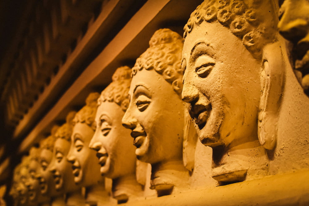 a row of buddha heads on a shelf