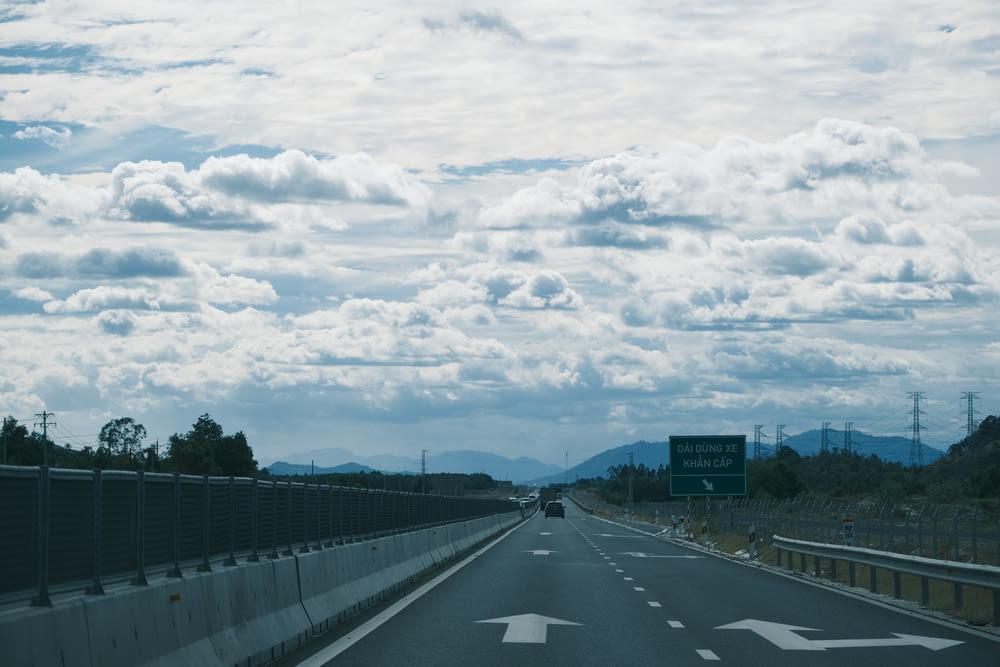 a highway with a bunch of clouds in the sky