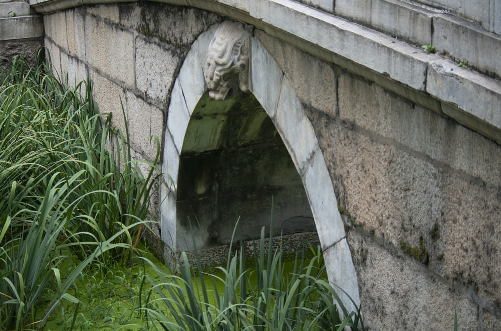 a stone bridge with a lion head on it
