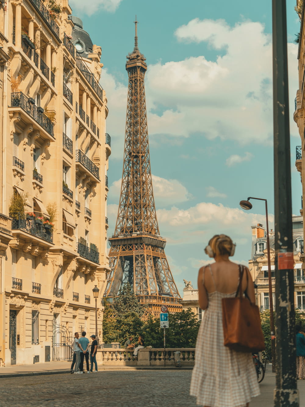 a woman in a white dress standing in front of the eiffel tower