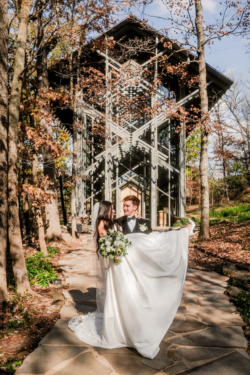 a bride and groom pose for a photo in front of a gazebo
