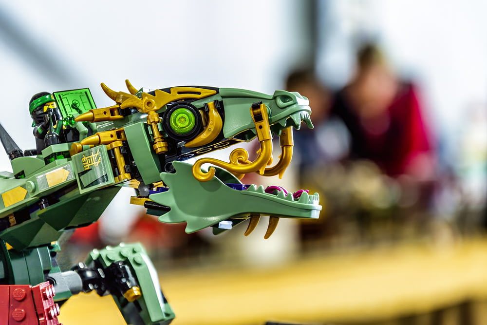 a green and yellow robot is on a table