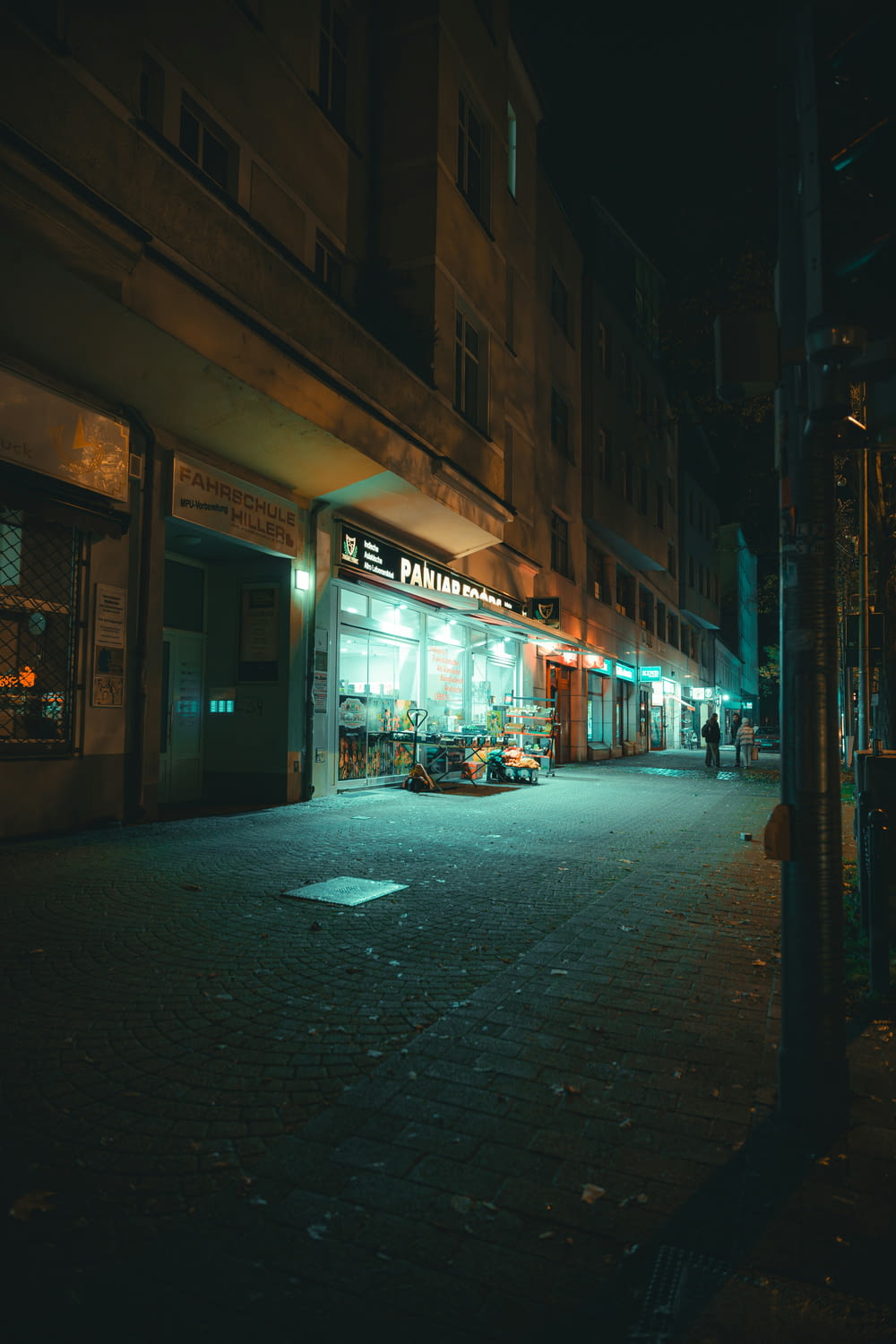 a dark city street at night with a store front