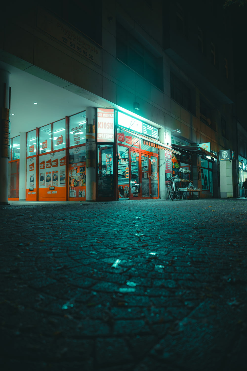 a street corner with a store lit up at night
