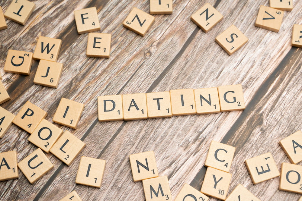 scrabble tiles spelling the word dating on a wooden table