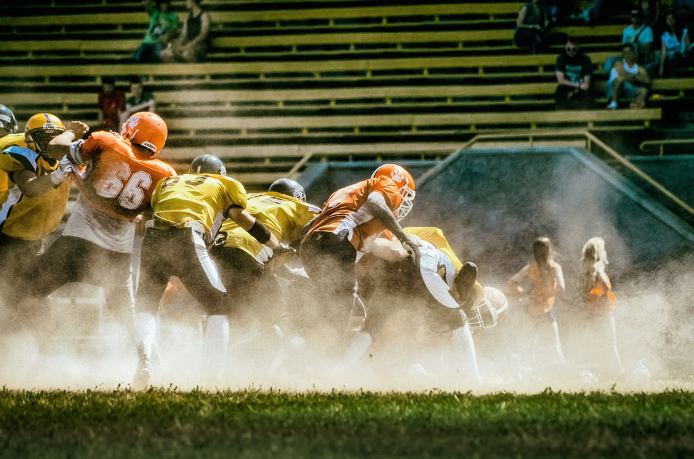 a group of football players running onto the field
