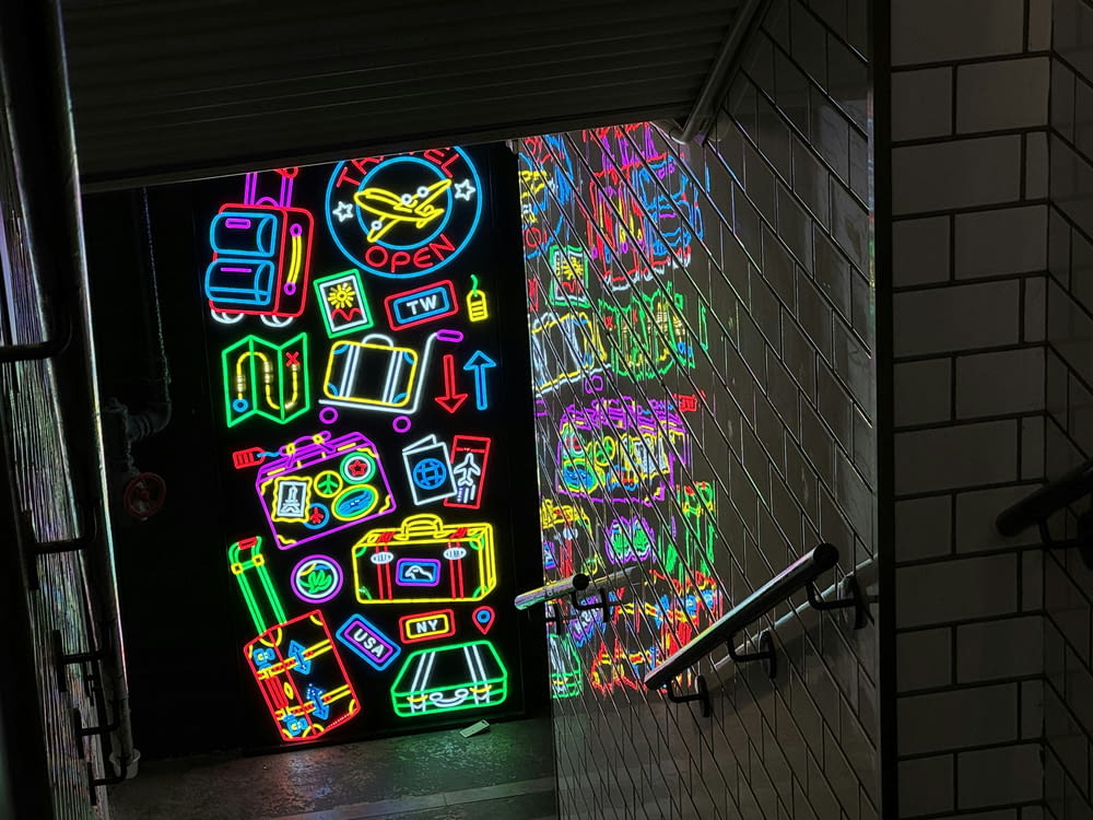a wall of neon signs in a dark room