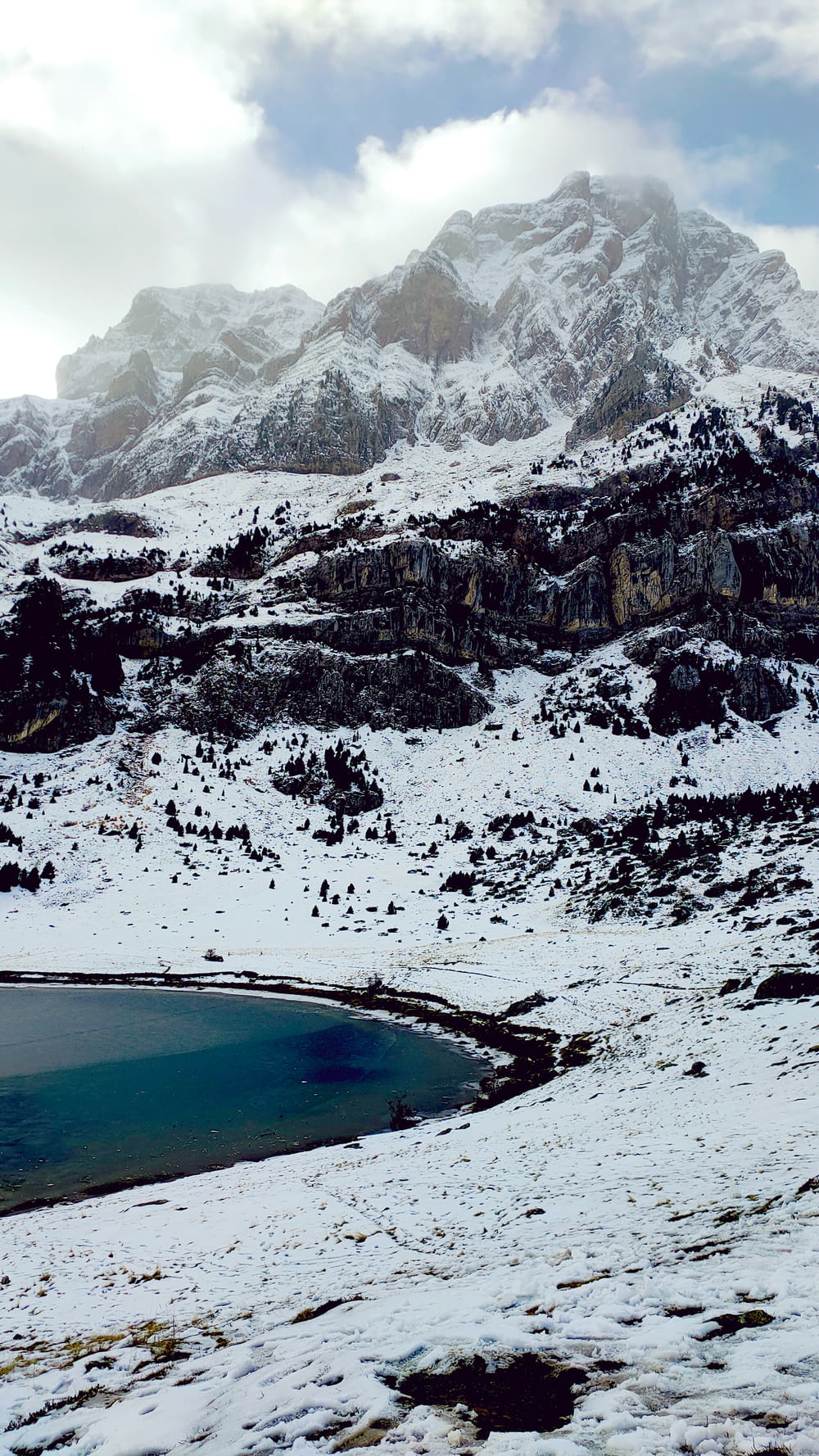 a snow covered mountain with a lake in the foreground