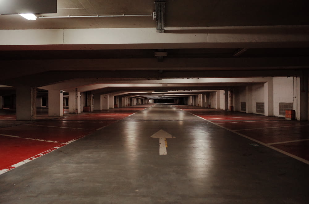 an empty parking garage with a red floor