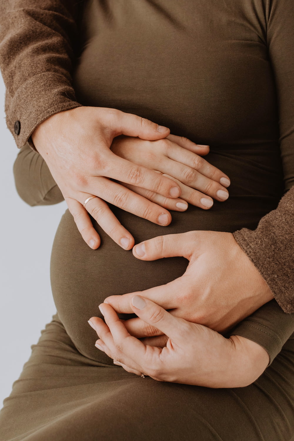 a pregnant woman holding her hands on her stomach