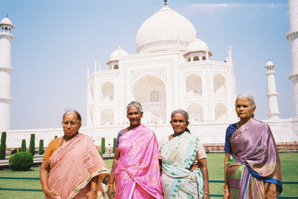 a group of women standing in front of a white building