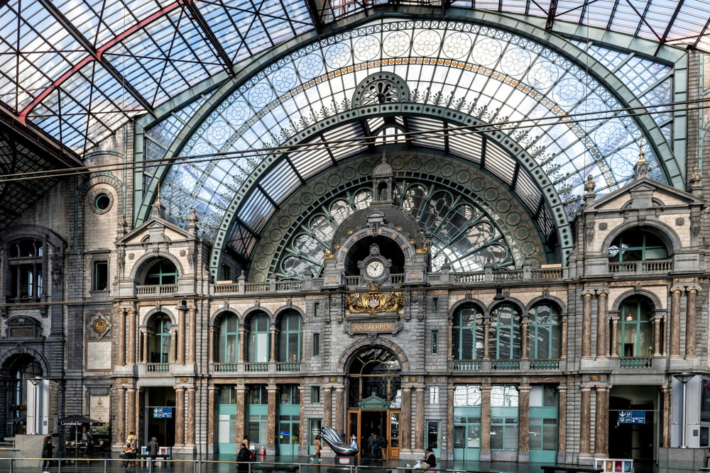 a train station with a glass ceiling and a clock