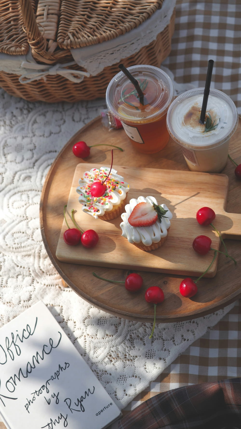 a wooden tray topped with cupcakes and drinks