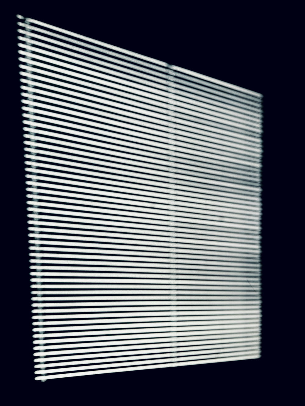a black and white photo of a window with blinds
