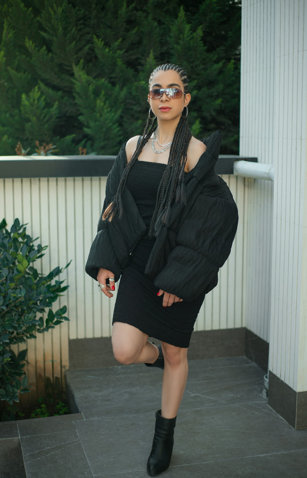uma mulher em um vestido preto e jaqueta posando para uma foto