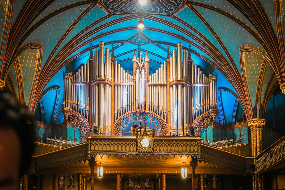 a large pipe organ in a church with a clock