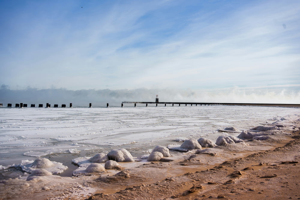Ein schneebedeckter Strand neben einem Pier