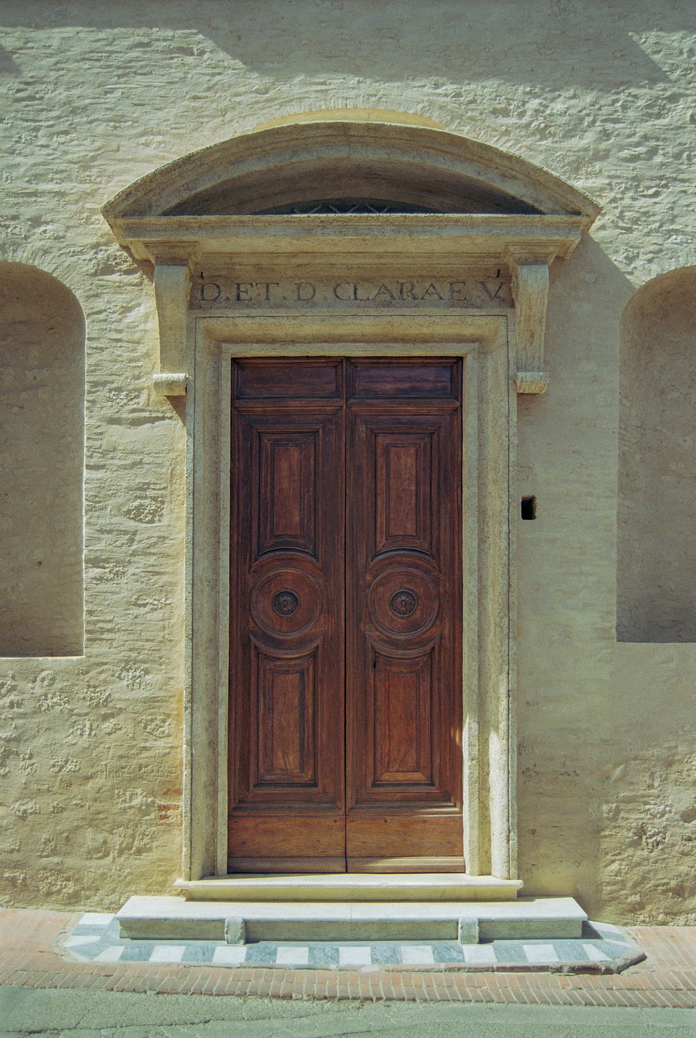 uma grande porta de madeira sentada em frente a um edifício de pedra