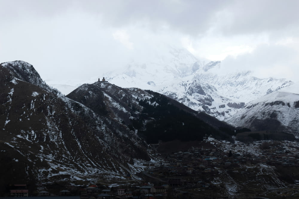 a snowy mountain range with a town below