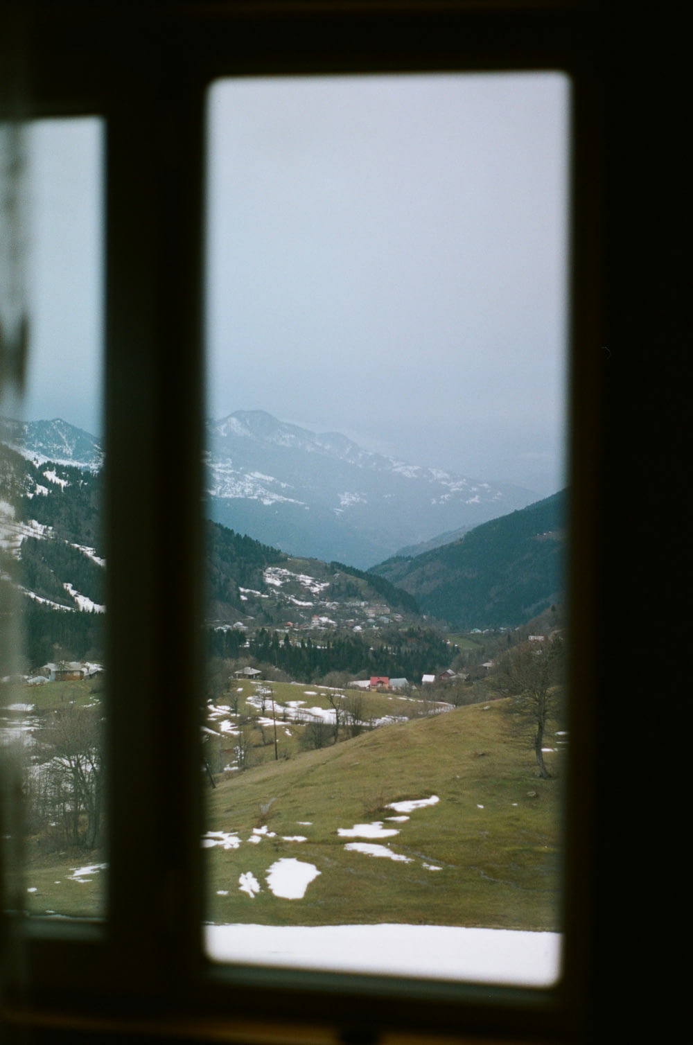 a view of a snowy mountain range from a window