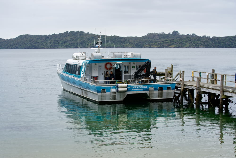 a blue and white boat docked at a pier