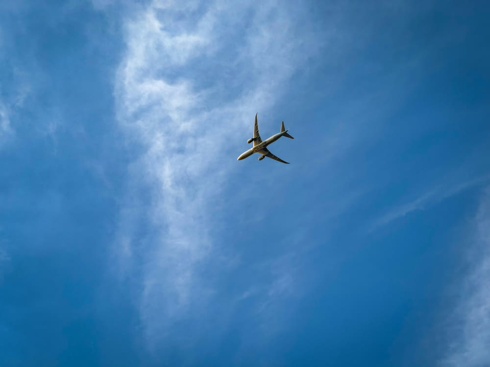 an airplane is flying through the blue sky