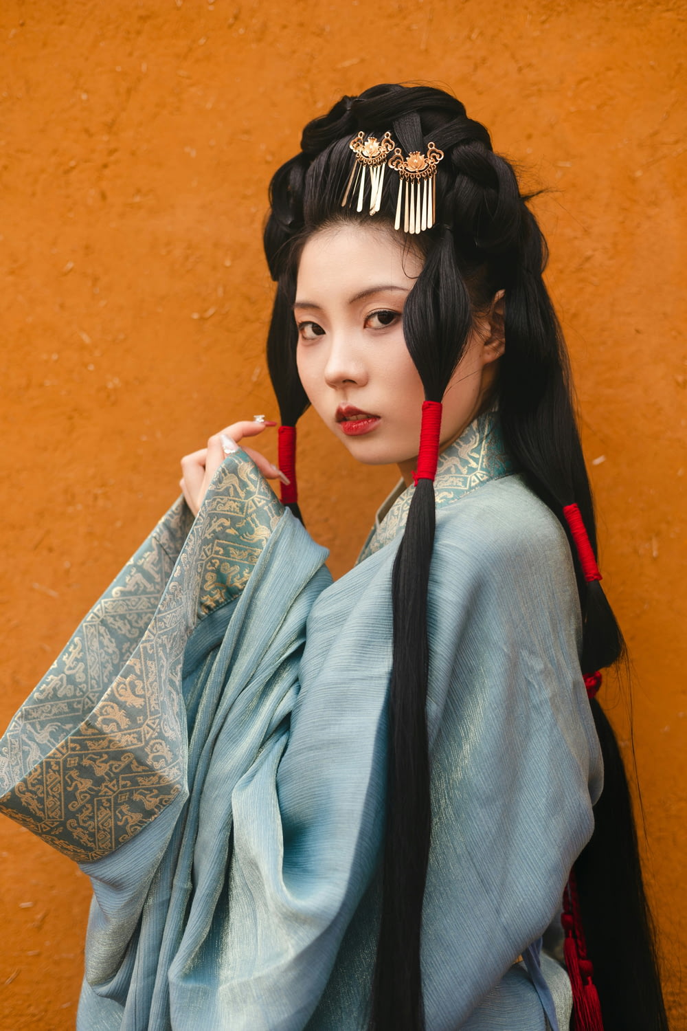 a woman with long black hair wearing a blue kimono