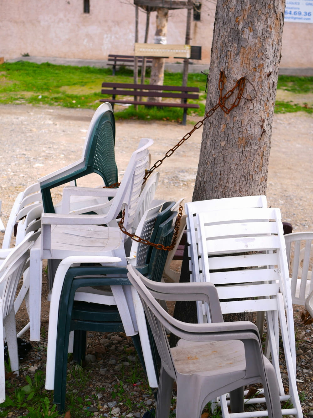 a bunch of chairs that are chained to a tree