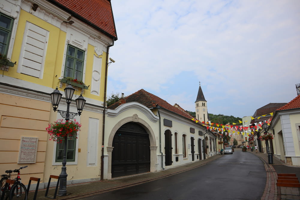a street lined with buildings with a clock tower in the background