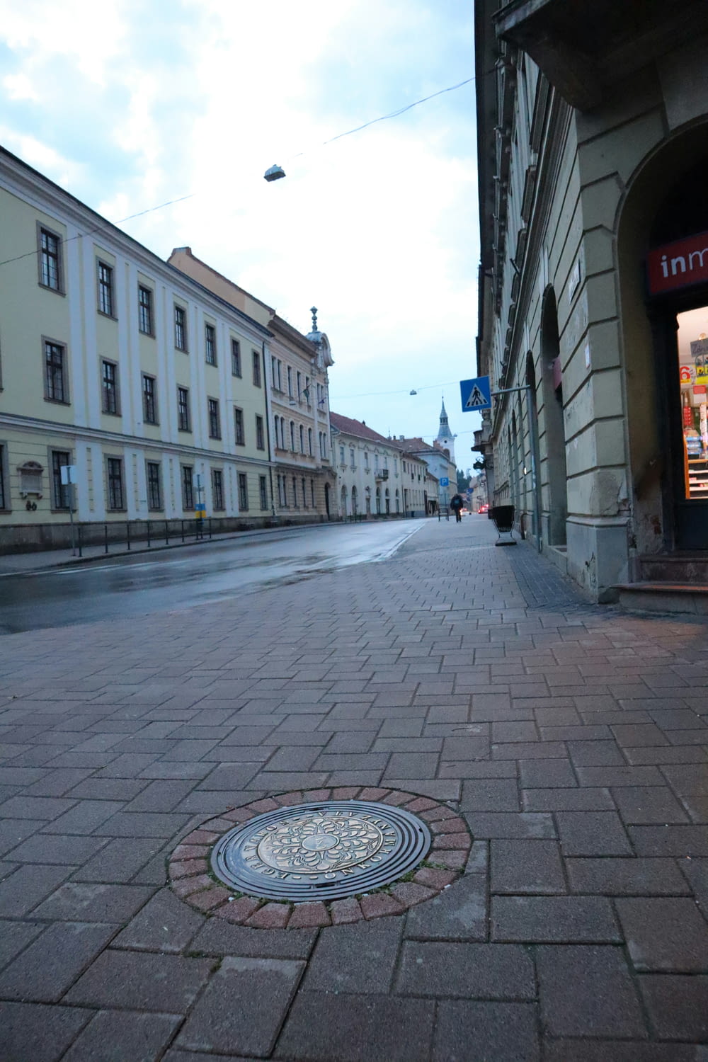 a manhole cover on a brick street with buildings in the background