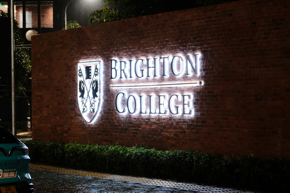 a brick wall with a sign that says brighton college