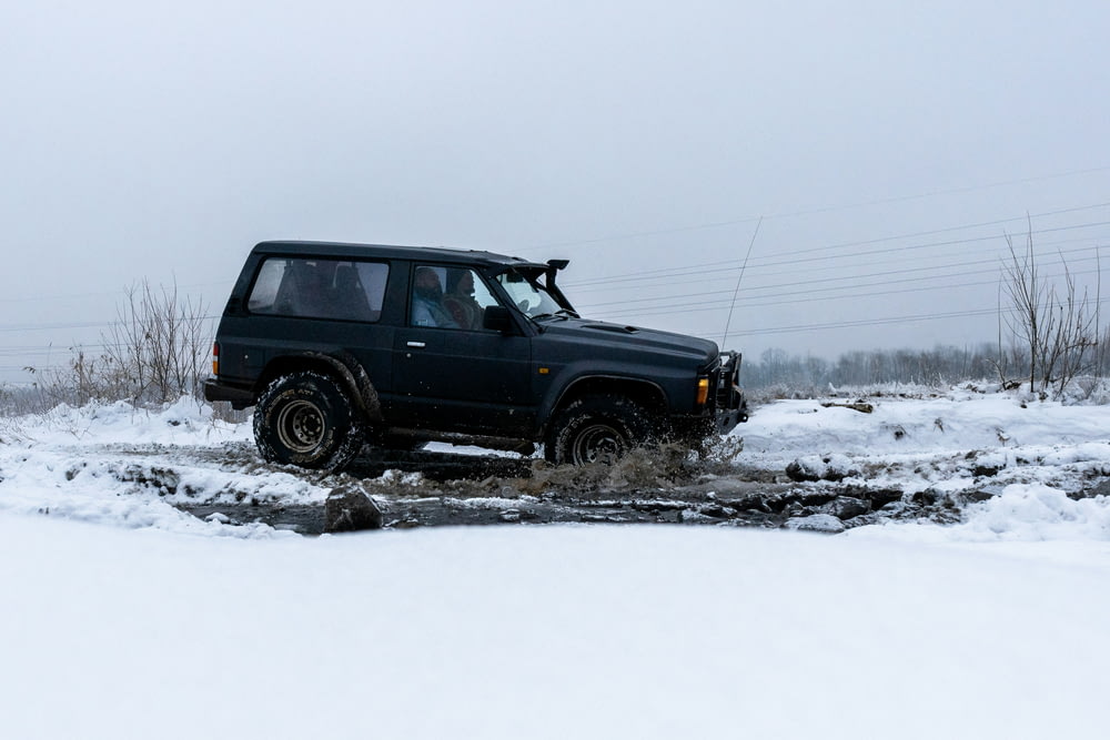 Ein Jeep, der durch eine Pfütze im Schnee fährt