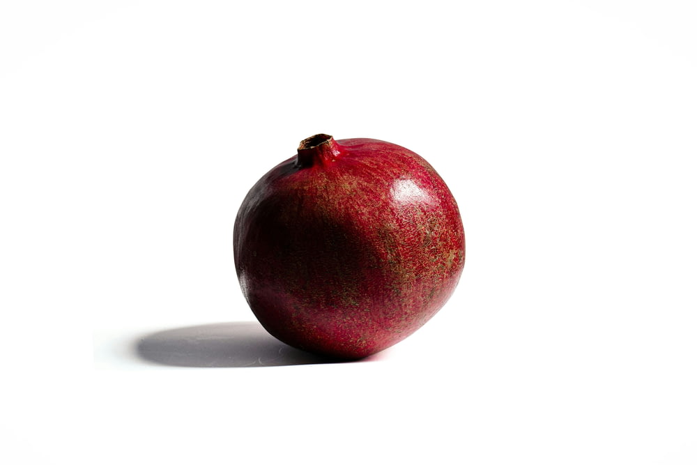 a red apple sitting on top of a white table
