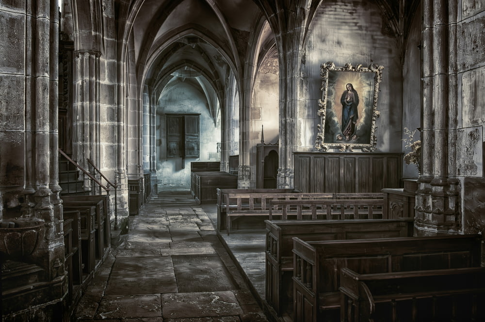 a church with pews and a painting on the wall