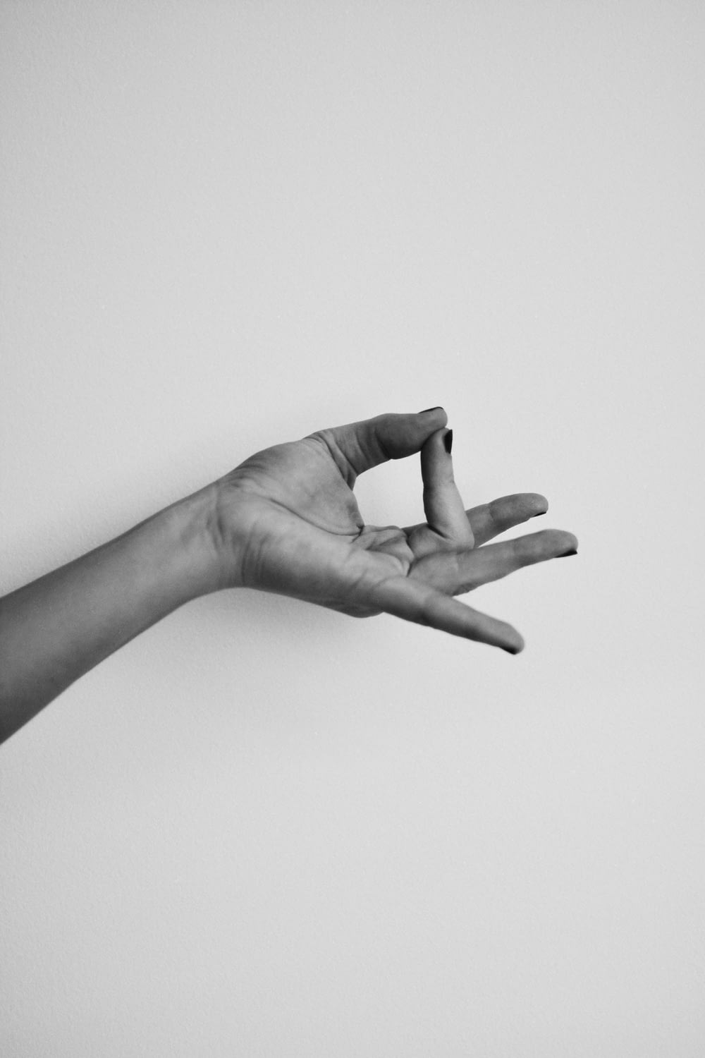 a black and white photo of a person's hand reaching for something