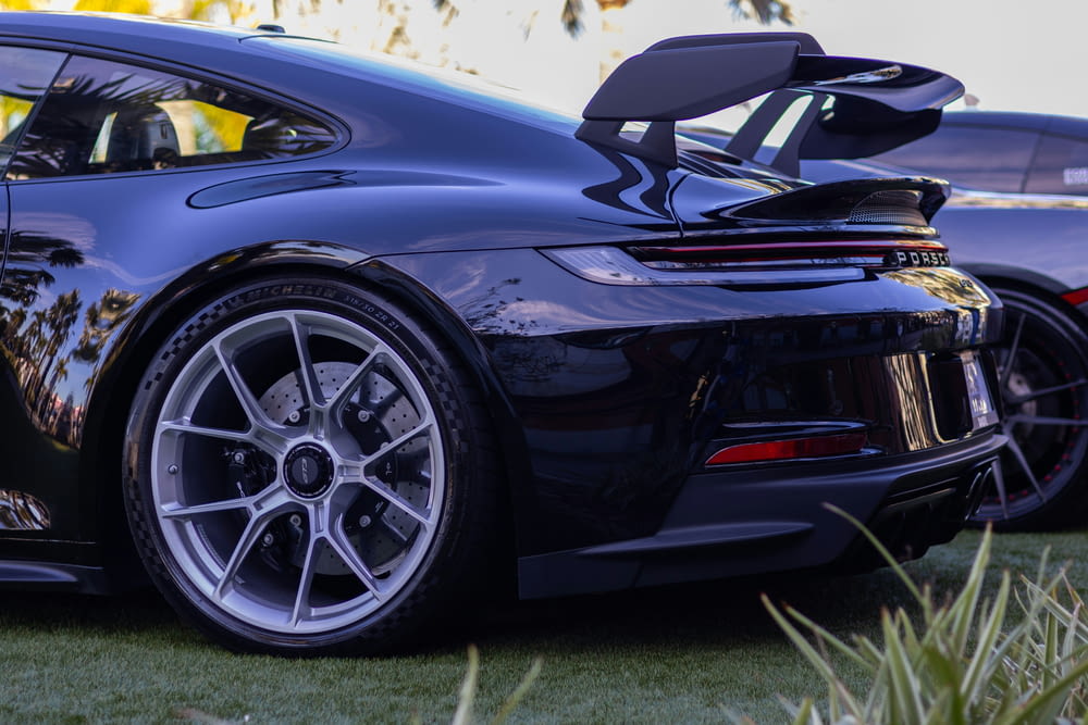 a black sports car parked in a grassy area