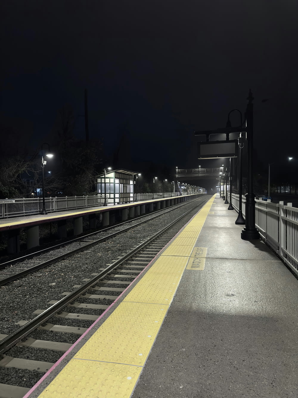 a train station at night with a train on the tracks