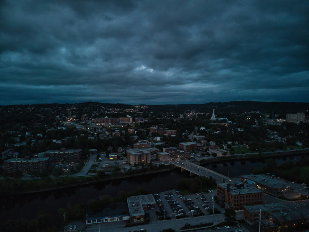 a view of a city at night with dark clouds
