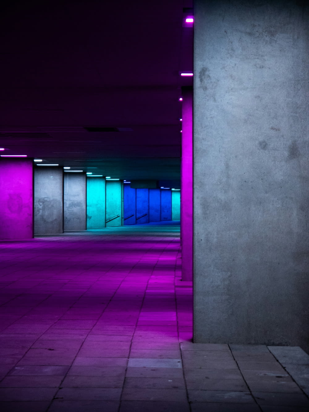 an empty parking garage with purple and blue lights