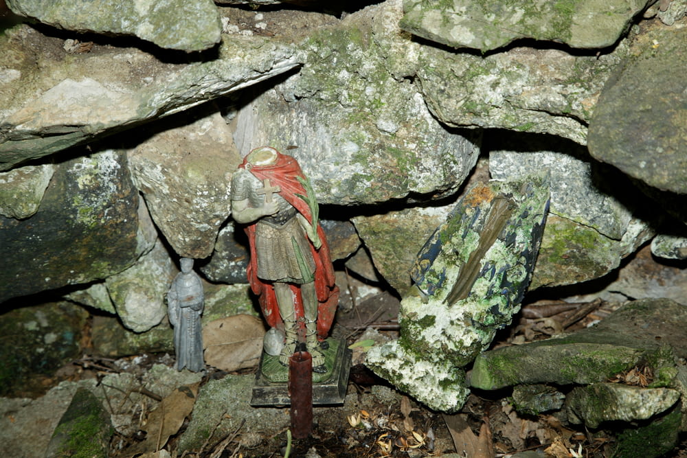 une statue d’un homme dans une grotte de pierre