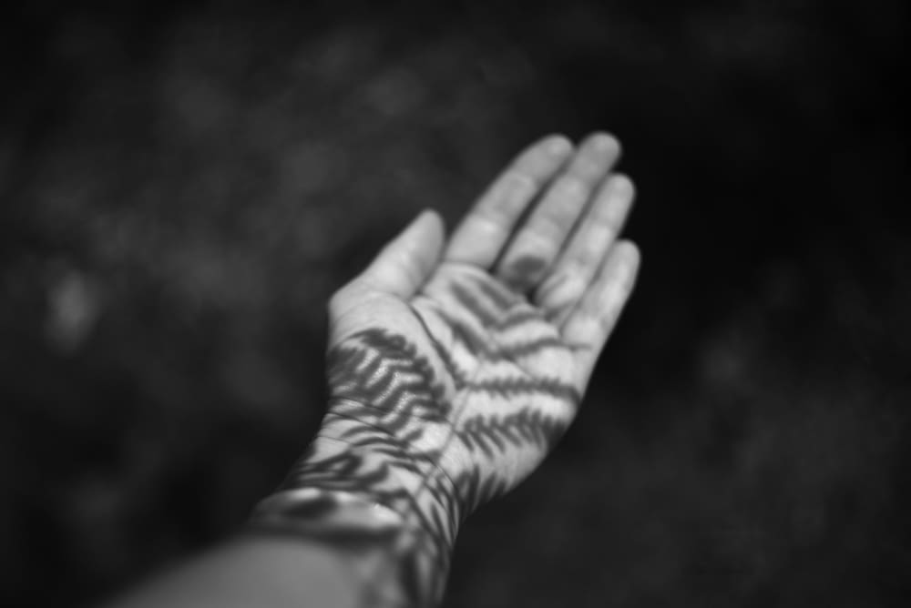 a black and white photo of a person's hand with a pattern on it
