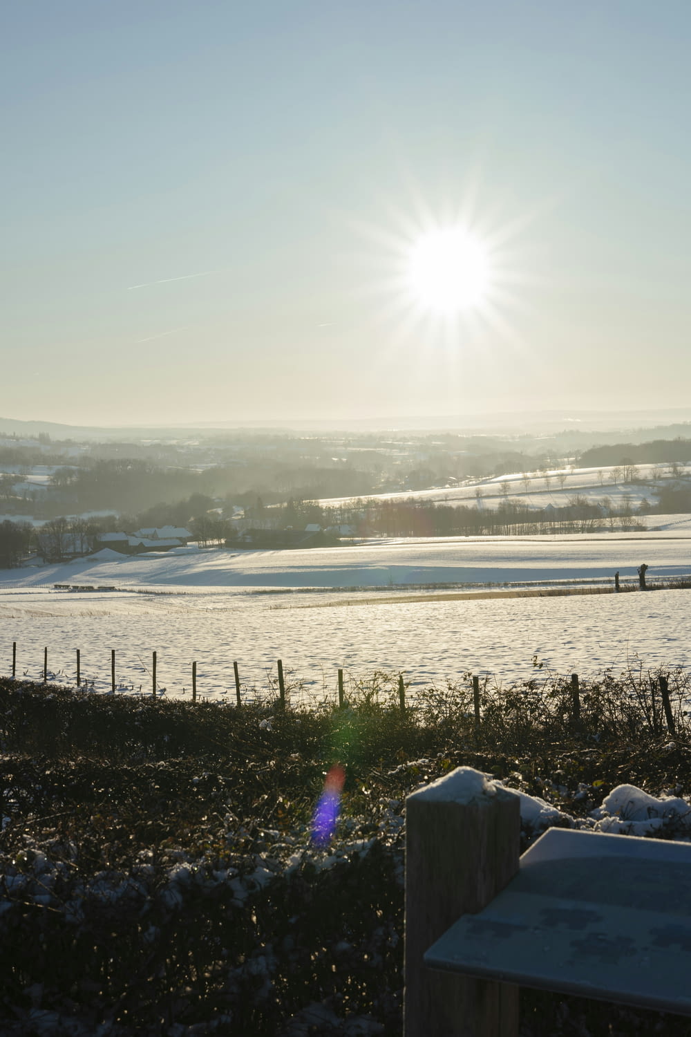 the sun is shining over a snowy field