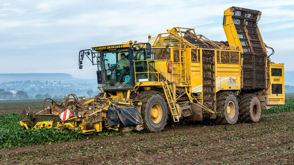 a tractor is plowing a field of crops
