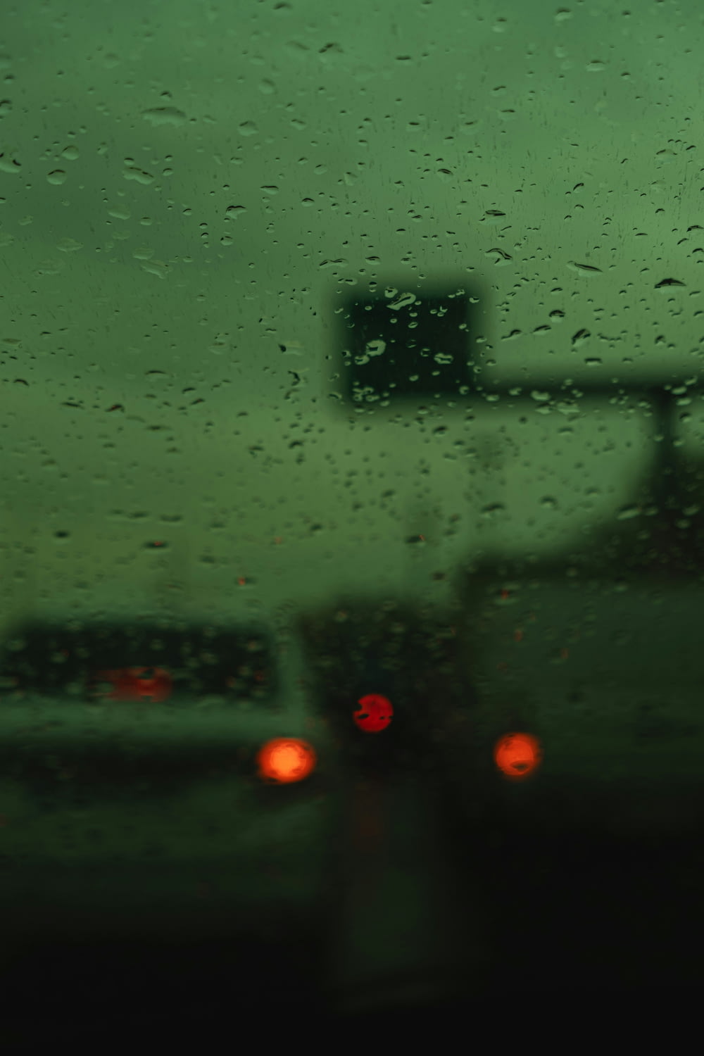 a view of traffic through a rain covered windshield